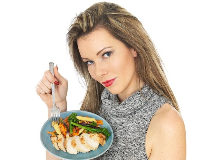 flicka som äter kyckling med grönsaker för viktminskning